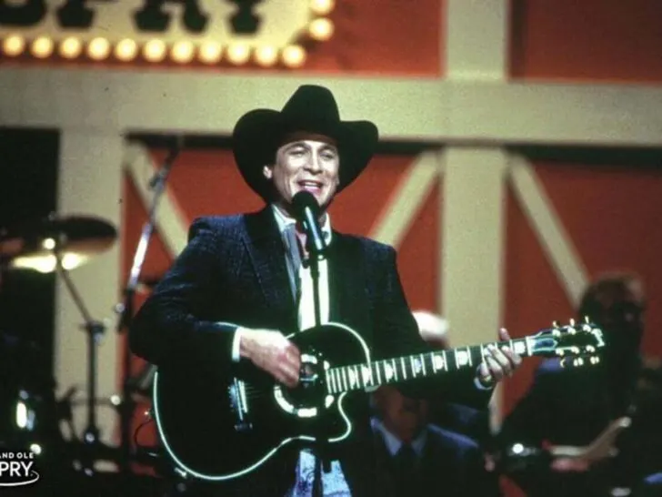 Young Clint Black singing with guitar on stage
