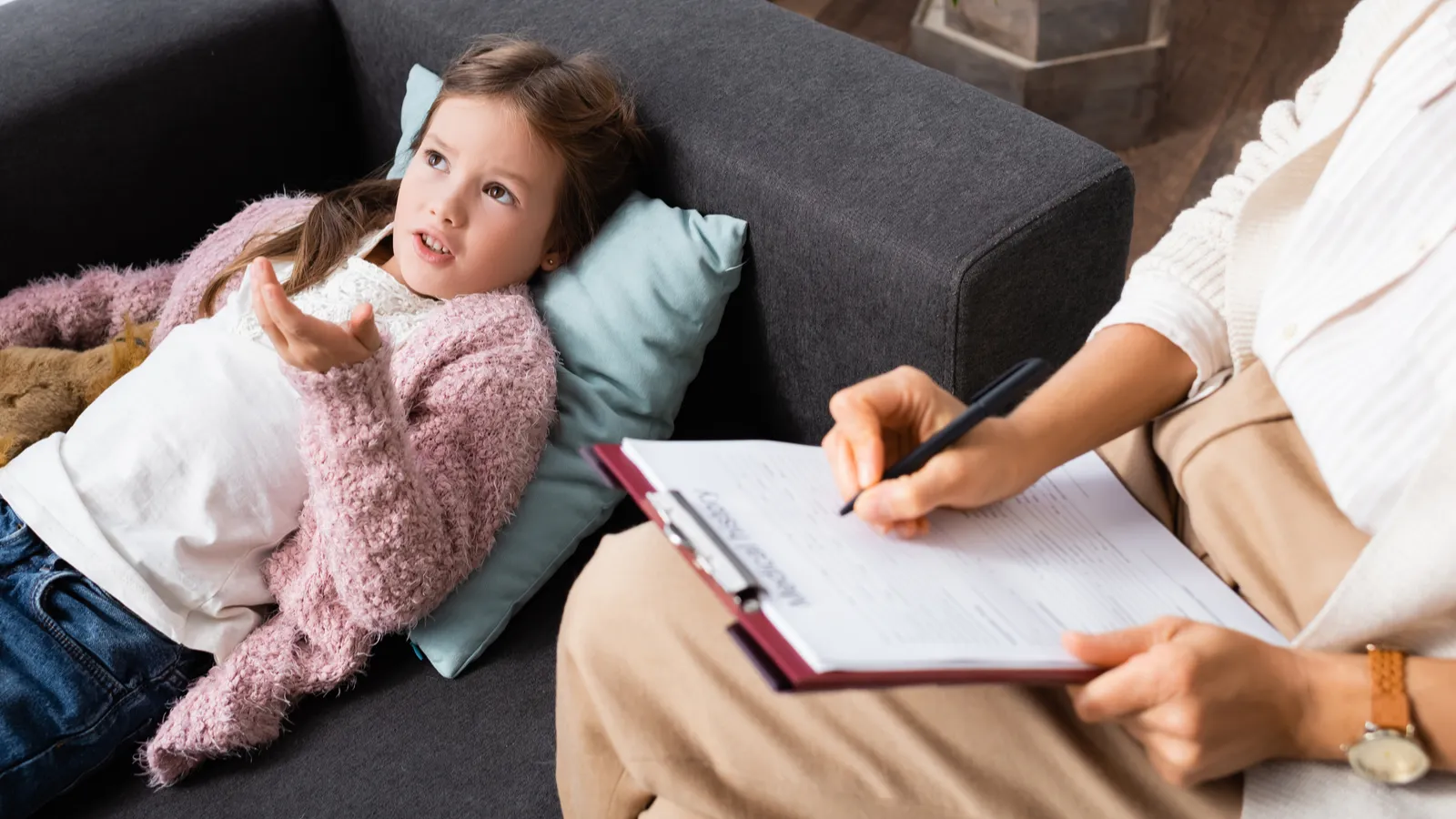 Telling Problem Image little girl lying on sofa with toy while telling problem to ...